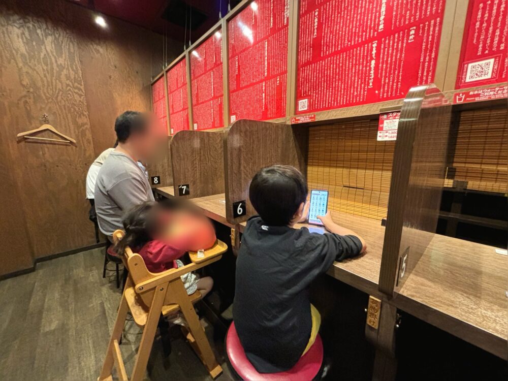 「一蘭」で子どもと一緒にカウンター席に座る