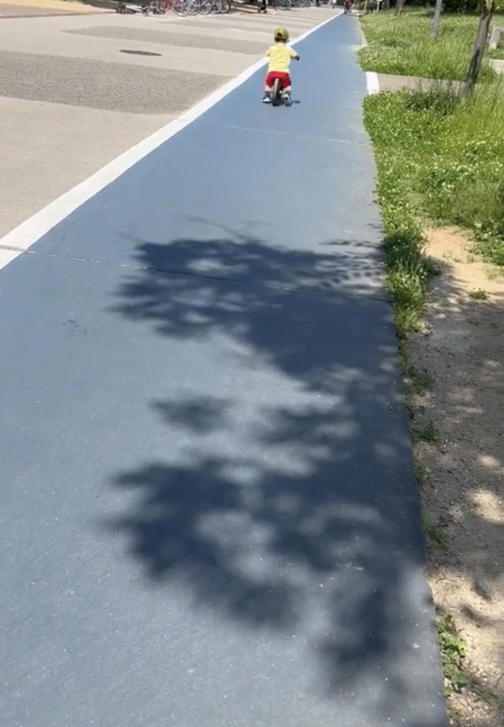 はるか遠くをストライダーで走っている子ども