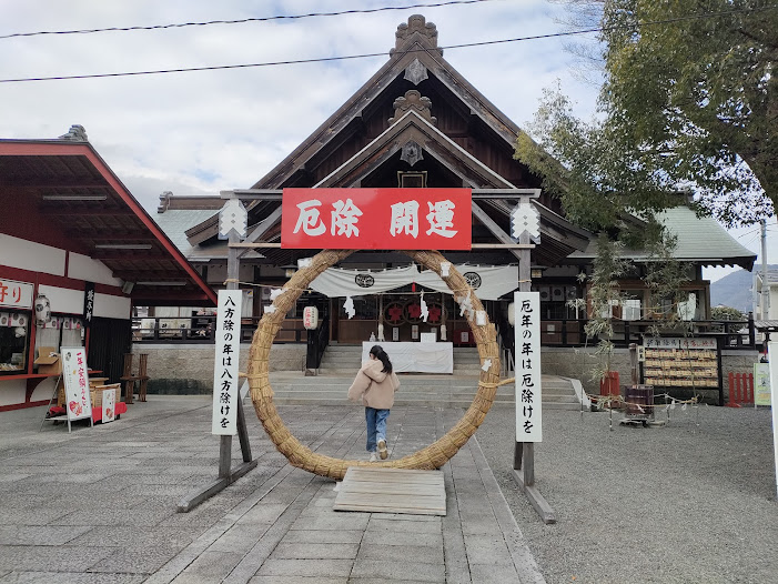 茅の輪くぐりの大きな輪をくぐる子ども
