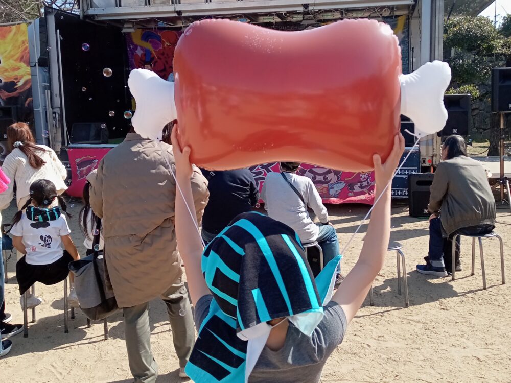 肉のふうせんを持ってはりきっている息子