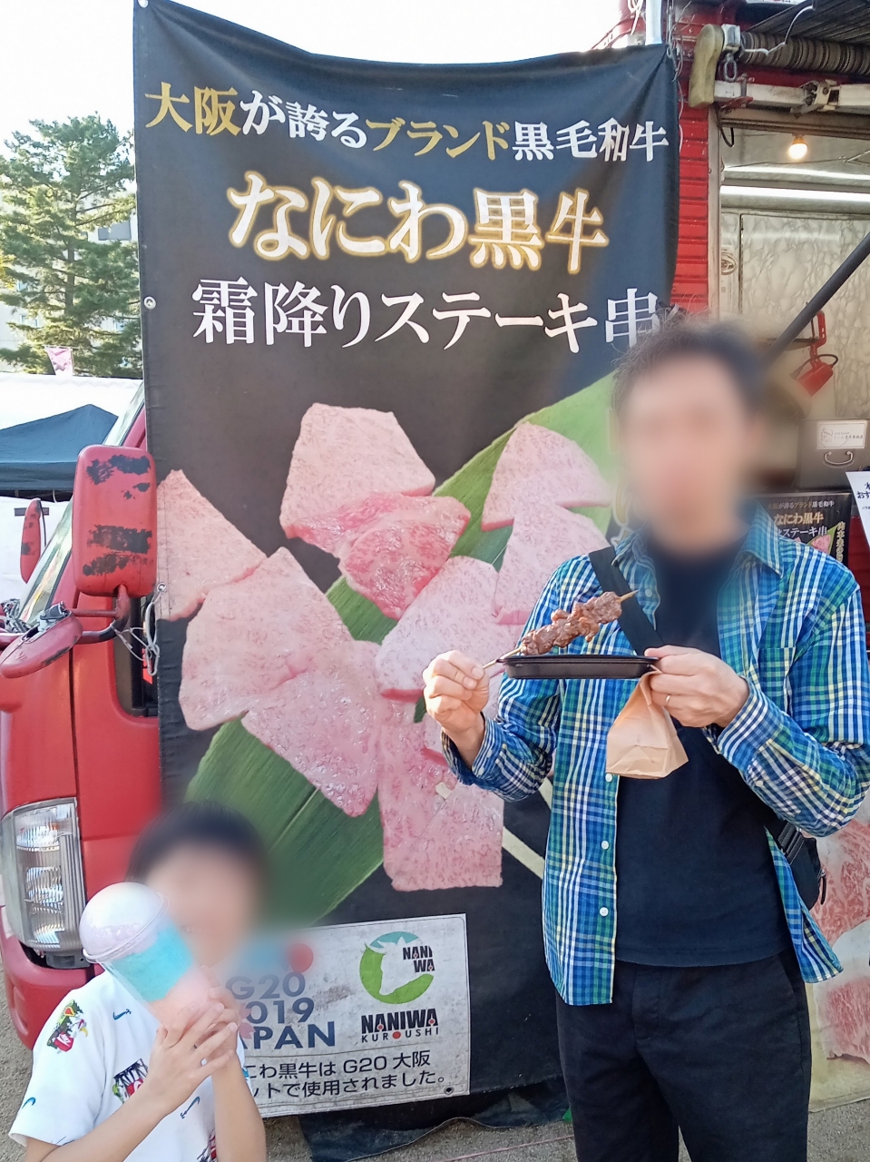 綿あめや肉串を持っている親子